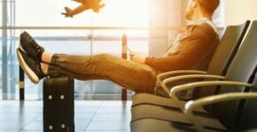 A man sitting at an airport considering the benefits of moving your career abroad.
