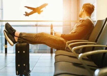 A man sitting at an airport considering the benefits of moving your career abroad.