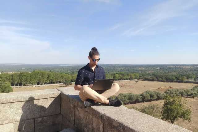 Photo of a young man sitting on a wall as a featured image for post about best jobs for digital nomads