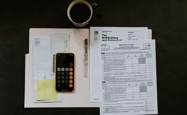 Paper a phone and coffee on the table for freelancers' bookkeeping.