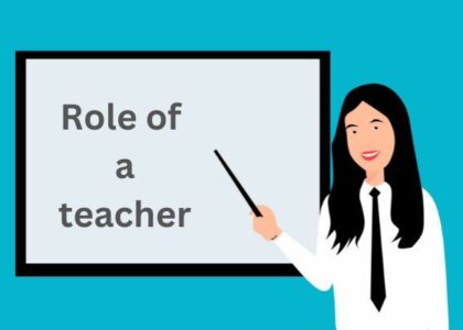 A teacher pointing stick to "role of a teacher" written on white board.