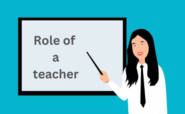 A teacher pointing stick to "role of a teacher" written on white board.